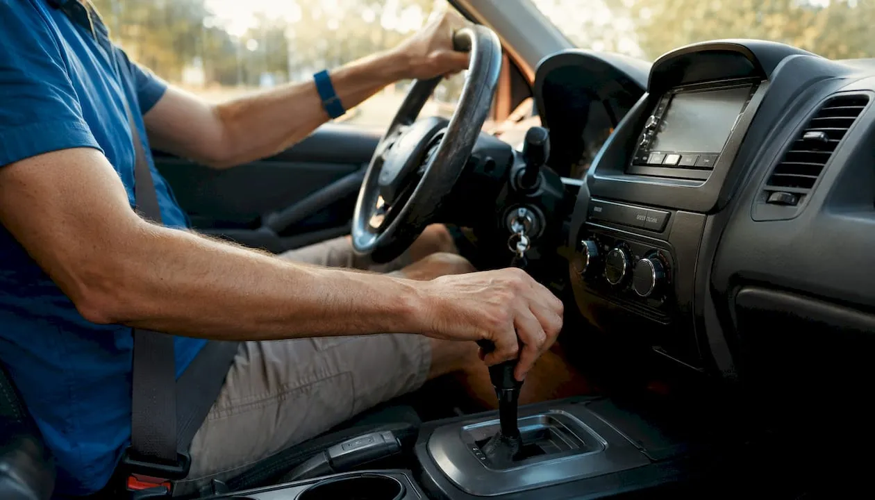 Driver shifting gears inside car