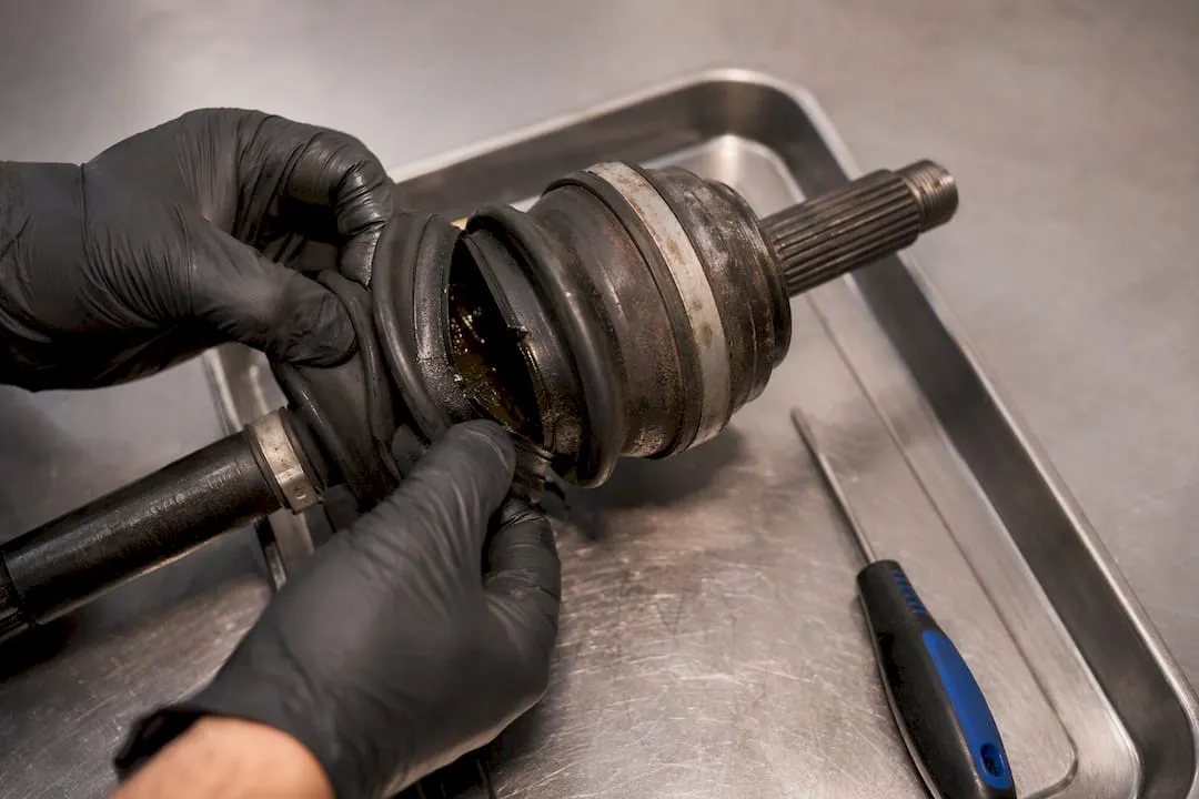 Technician examining a torn CV axle boot